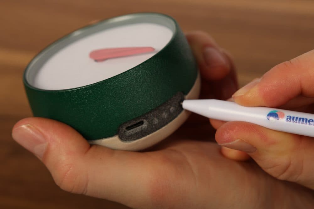 Met het pennetje op de verzonken knop van Het Kompas drukken
