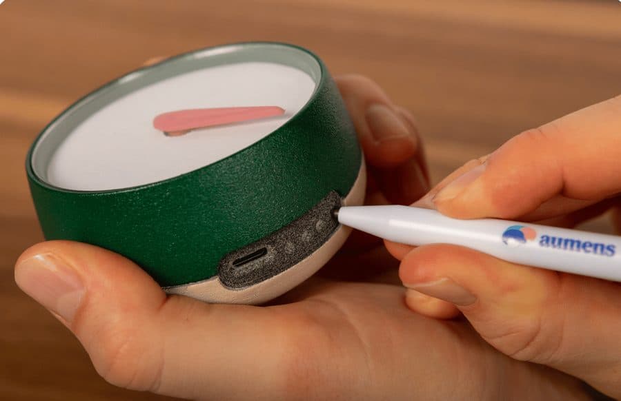 Met het pennetje op de verzonken knop van Het Kompas drukken